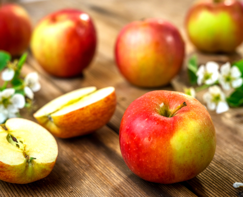 Raw organic apples on wooden background