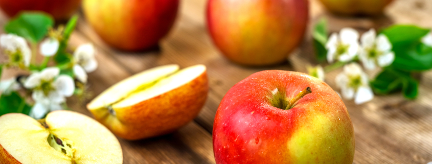 Raw organic apples on wooden background